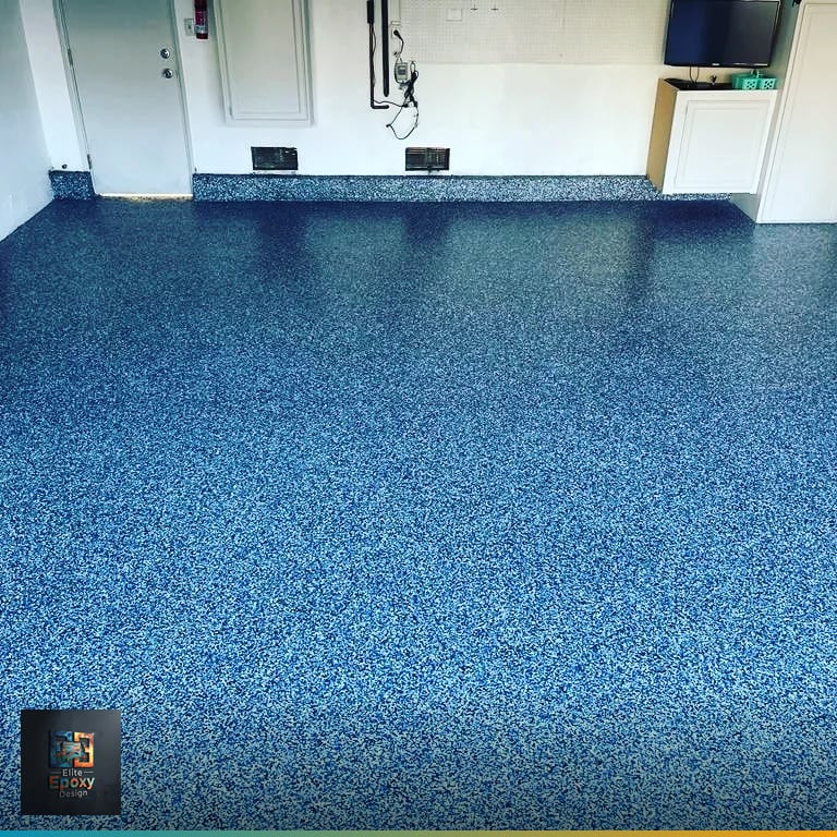 Cobalt blue vinyl flake epoxy floor covering a residential garage with white walls and a coved edge