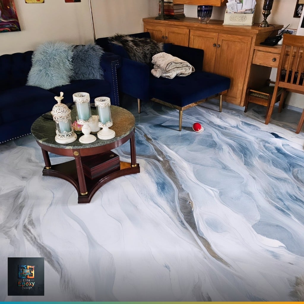 White and gray marble-effect metallic epoxy floor in a furnished living room with a navy sofa and round center table